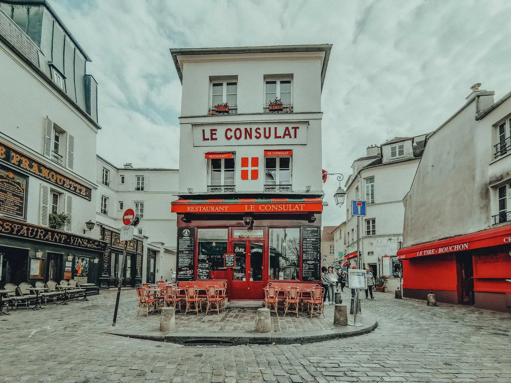 Photo d'une rue enneigée à Montmartre avec le Sacré-Cœur en arrière-plan